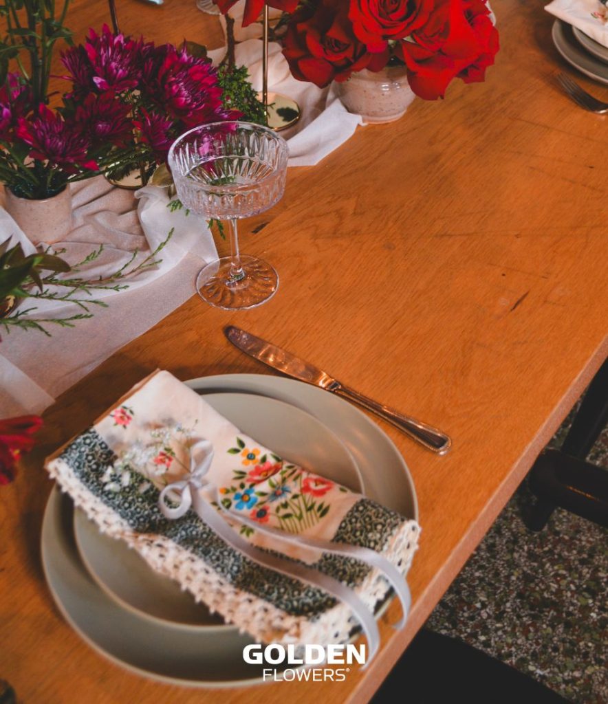 napkins arranged on a plate next to holiday flowers, representing a family table tradition.